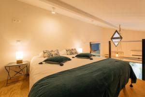 - une chambre avec un grand lit et 2 oreillers verts dans l'établissement Appart Hotel Eugenie, à Louhans