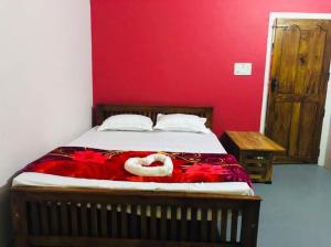 a bedroom with a bed with a red wall at Safayar holidays Ramakkalmedu in Ramakkalmedu