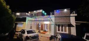 a white car parked in front of a house at night at Safayar holidays Ramakkalmedu in Ramakkalmedu +12 photos