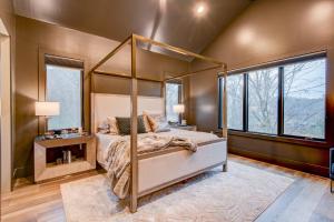 Un dormitorio con cama con dosel y ventanas. en Maynard V at Elk Creek, en Banner Elk