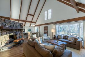 a living room with couches and a stone fireplace at Mountain Bliss at Hound Ears in Valle Crucis