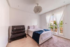Un dormitorio con una cama y una cómoda y una ventana. en Villa Zen, piscine privée et plage, en Casablanca
