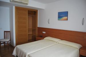 a bedroom with a bed and a chair in it at Hotel Plaza in Portonovo