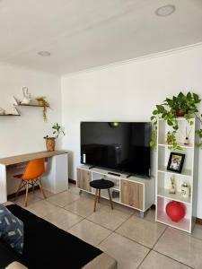 a living room with a flat screen tv and a couch at Departamento moderno en el centro de Posadas in Posadas