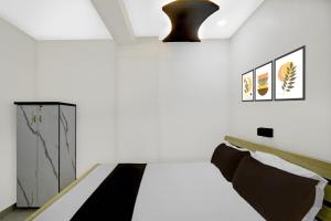 a bedroom with a bed and a pendant light at Hotel O De' BVL Grand in Hyderabad