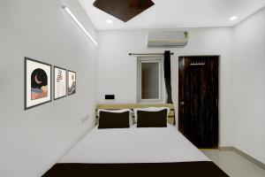 a bedroom with a white bed and a window at Hotel O De' BVL Grand in Hyderabad +21 photos