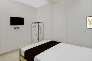 a bedroom with a bed and a tv on the wall at Hotel O De' BVL Grand in Hyderabad