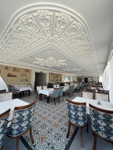a dining room with tables and chairs and a ceiling at Art Minor Khiva in Khiva