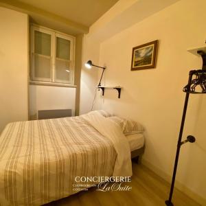 a bedroom with a bed and a lamp at La Passerelle in Cherbourg en Cotentin