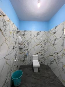 a bathroom with a white toilet in a room at Mantan Stay in Tadri