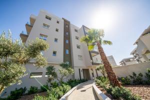 Aglantziaにある1 bedroom flat next to universityの前にヤシの木がある建物