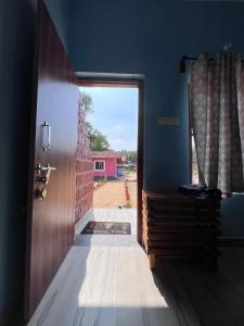 a door leading into a room with a brick wall at Mantan Stay in Tadri +17 photos