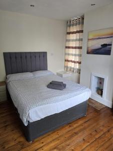 a bedroom with a large bed with a gray headboard at Coundon Fields in Allesley