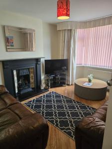 ein Wohnzimmer mit Sofa und Kamin in der Unterkunft Coundon Fields in Allesley