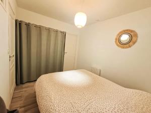 a bedroom with a bed and a mirror on the wall at Le Rez des Arcades - T2 en RDC hypercentre in Carentan +7 photos