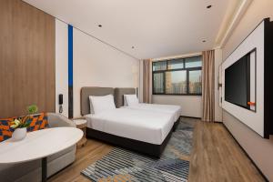 a hotel room with a bed and a tv at Holiday Inn Express Shanghai Changyang Road by IHG in Shanghai