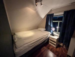 a small bedroom with a bed and a window at Cozy familyhouse with free parking & fantastic view in Tromsø