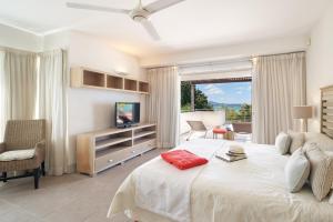 a bedroom with a large bed and a television at Cape Point Beachfront Residences by LOV Mauritius in Cap Malheureux +46 photos