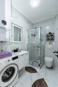 a white bathroom with a shower and a washing machine at Kaltak Luxury Stay in Bar +46 photos