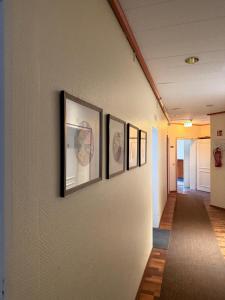 a hallway with four framed pictures on a wall at HOTEL S Norderstedt in Norderstedt +16 photos