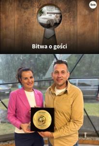 a man and a woman holding a plaque in front of a camera at Pokoje Hotelowe "Lila" Siedlce in Siedlce