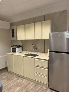 Una cocina con frigorífico de acero inoxidable y fregadero. en مذهله للوحدات السكنيه, en Muhayil