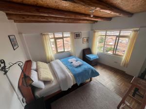 a bedroom with a bed and two windows at Sky Garden in Cusco