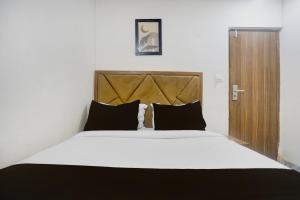 a bedroom with a large white bed with black pillows at Hotel O Beverly Plaza Kurla in Mumbai