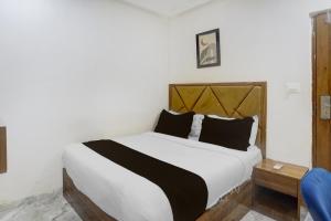 a bedroom with a white bed with black pillows at Hotel O Beverly Plaza Kurla in Mumbai
