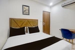 a bedroom with a bed and a blue chair at Hotel O Beverly Plaza Kurla in Mumbai +28 photos