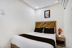 a bedroom with a bed and a vase of flowers at Hotel O Beverly Plaza Kurla in Mumbai