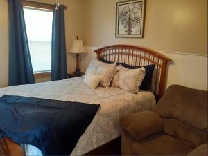 - une chambre avec un lit doté d'oreillers et d'une chaise dans l'établissement Cottage 1 on Ranch with Fishing & Camping, à McKinney