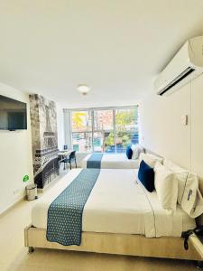Un dormitorio con una cama grande y una ventana grande. en Hotel Laureles Plaza, en Medellín