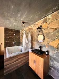 a bathroom with a bath tub and a sink at Cabañas San Marcos in Mazamitla