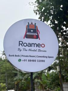 a sign for a hotel with a backpack on it at Roameo, Varkala - A Cowork by The Hostel Stories in Varkala