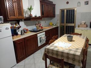 a kitchen with a table and a white refrigerator at OldHouse in Albergo