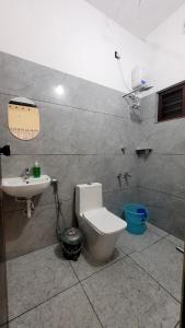 a bathroom with a toilet and a sink at Roameo, Varkala - A Cowork by The Hostel Stories in Varkala