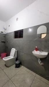 a bathroom with a sink and a toilet and a mirror at Roameo, Varkala - A Cowork by The Hostel Stories in Varkala