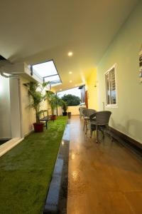 a room with a green lawn and a table and chairs at Green Home Stay - 10 Mins Walk to Kanyakumari Main Beach in Kanyakumari