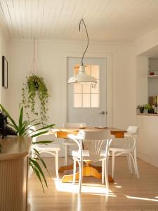 a white dining room with a table and chairs at Le Boulevard par Maison Dudley in Lac-Mégantic