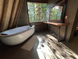 a bathroom with a bath tub and a window at Tree of Life Chalet in Brumadinho