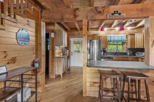 cocina con paredes de madera y suelo de madera en The Great Bear Lodge, en Vilas