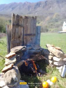 a fire pit with logs and rocks in a field at Zeko Farm in Gjirokastër +5 photos