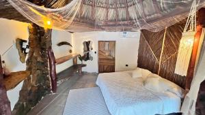 ein Schlafzimmer mit einem Bett in einem Zimmer in der Unterkunft Tawaca SANCTUARY in Calabazo + 7 Fotos