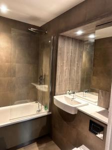 バーミンガムにあるCozy retreat in the heart of Birmingham City Centreの洗面台、浴槽、鏡のあるバスルーム
