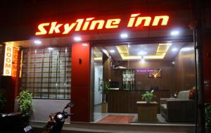 a sign for a skiline inn with a motorcycle parked outside at Skyline Inn in Anachal