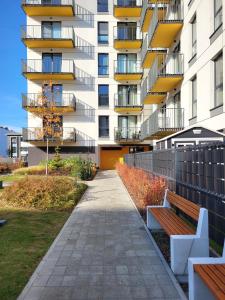 Un edificio con un banco delante de él. en Ursus Premium Apartments, en Varsovia