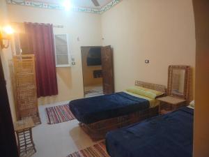 a bedroom with two twin beds and a mirror at agyptus camp in Siwa +18 photos