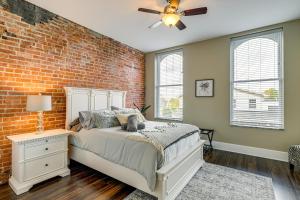 a bedroom with a bed and a brick wall at Luxurious Litfin Loft - Walk to Main St Akron in Akron