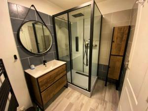 a bathroom with a sink and a mirror at Le Duplex des Arcades - T2 lumineux hypercentre in Carentan